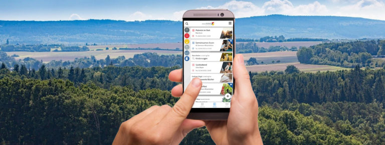 Handy mit Handy vor Wald im Hundsrück